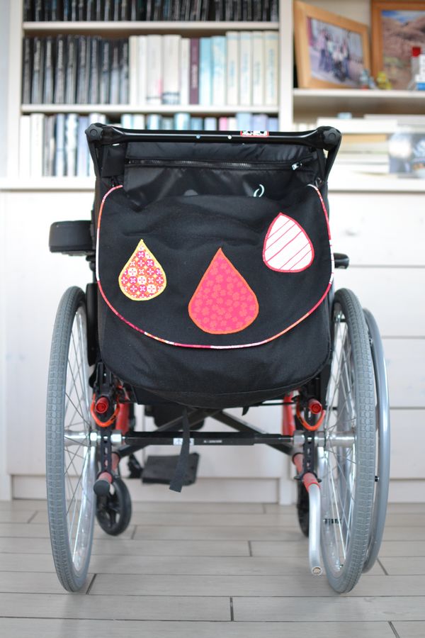 sac pour fauteuil roulant noir et détails orange et rouge