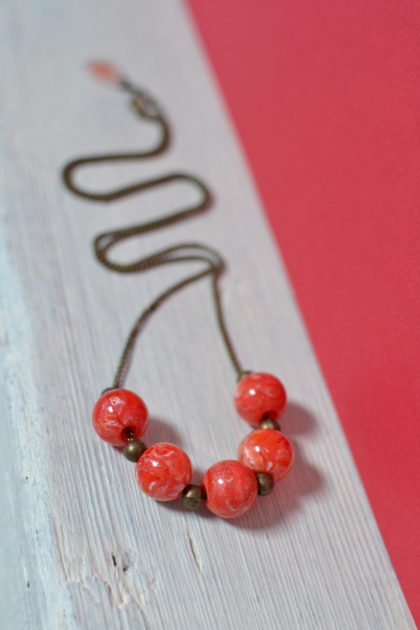 collier bronze et perles en résine rouge orange