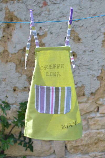 tablier vert clair, poche et liens rayés, customisé "cheffe Lina" et "Miam !"